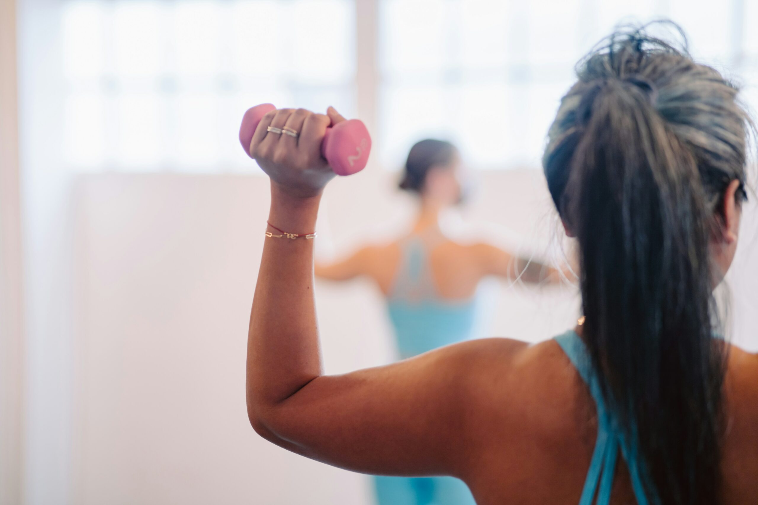 woman-using-handweight-in-barre-class