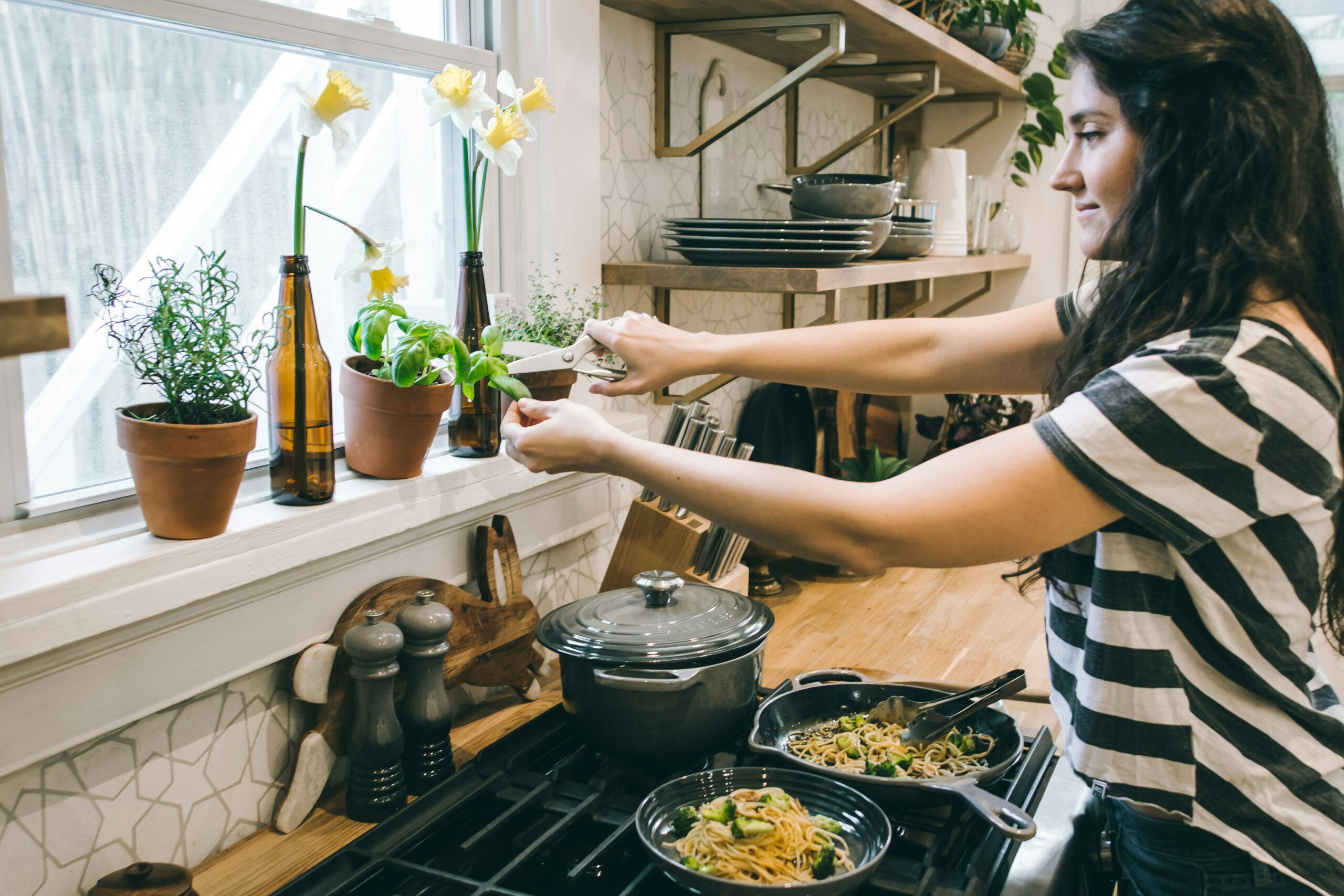 woman-using-herbs-to-cook-on-the-stove